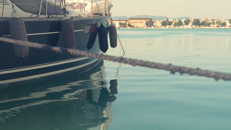 A-relaxing-shot-of-a-docked-boat-at-sea-with-a-slight-focus-pull-from-a-weathered-rope