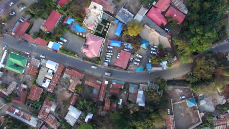 Aerial-View-of-Cars-Driving-Through-a-Village-in-Rural-Tanzania,-Top-Down-View