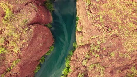 Drone-flying-high-above-a-red-rock-gorge-canyon-looking-straigh-down