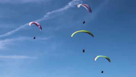 Beautiful-shot-of-Parasailors-floating-high-in-the-sky-playing-in-the-wind