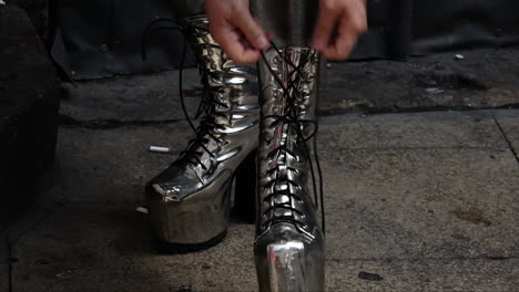 UK-July-2018---A-Drag-Queen-wearing-a-white-wig-and-science-fiction-style-silver-leotard-laces-up-silver-high-heel-platform-boots