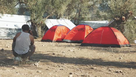 New-arrival-refugee-talks-on-his-phone-sitting-alone