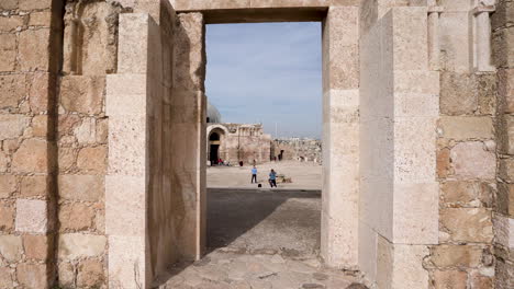 Ancient-Ruins-of-Stone-Wall-With-Preserved-Entrance-with-a-Islamic-Achitecture-Building-in-the-Background