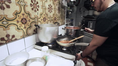 Chef-cooking-tomatoes-sauce-in-a-restaurant-in-Florence-Italy-Tuscany