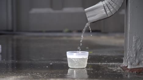 Regenwasser-Aus-Einem-Fallrohr-Sammelt-Sich-Mit-120-Bildern-Pro-Sekunde-In-Einer-Tasse