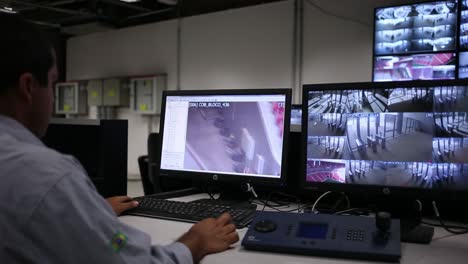 Security-guard-examines-the-Mane-Garrincha-Stadium-through-a-security-camera