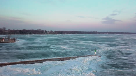 Eine-Weitreichende-Aufnahme-über-Einem-Leuchtturm-Auf-Einem-Pier-Zeigt-Kilometerlanges-Eis-über-Einem-Riesigen-Zugefrorenen-See