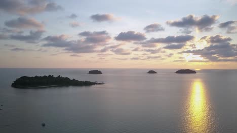 A-slow-aerial-shot-from-a-drone-of-a-beatufiul-sunset-and-dramatic-slighly-covered-with-clouds-sky,-Koh-Chang---Thailand