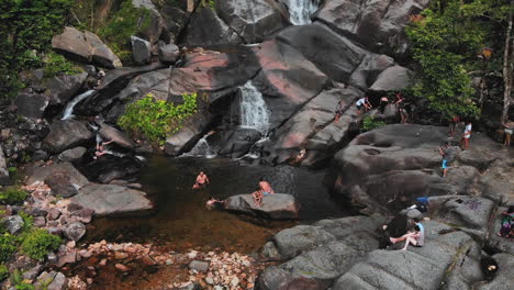 Locals-and-tourists-having-fun-at-the-base-of-a-beautiful-waterfall