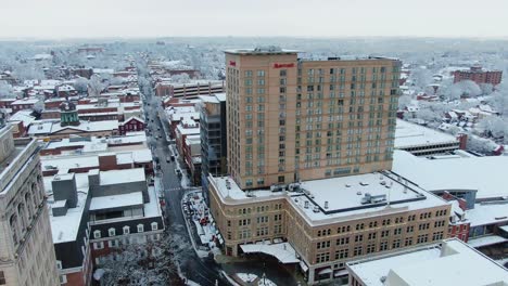 Downtown-Lancaster,-PA,-after-snowstorm,-Queens-street-with-Marriott-Hotel,-aerial-cityscape