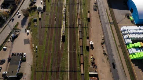 Vista-Aérea-De-Las-Vías-Del-Tren-Que-Van-Junto-Al-Puerto-Industrial-Hacia-La-Ciudad