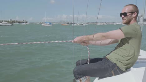 Cool-guy-with-sunglasses-clean-hitches-his-small-boat-to-wharf-in-waitemata-harbor