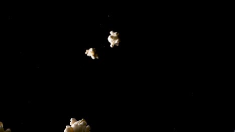 Popcorn-Fällt-In-Zeitlupe-Auf-Die-Kamera,-Isolierte-Studioaufnahme-Mit-Schwarzem-Hintergrund