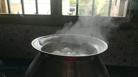 Olla-Cocinando-Arroz-De-Manera-Tradicional-Hirviendo-Agua-En-Un-Fondo-Negro-Con-Humo-Blanco-En-Cámara-Lenta