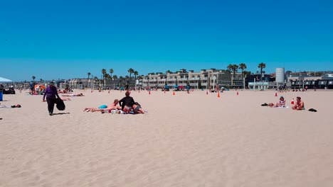 Panning-shot-of-Hermosa-Beach,-LA,-California-by-the-pier-on-a-beautiful-summer-day