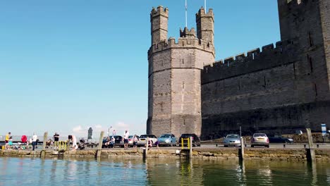 Caernarfon-Castle-Geschossen-Vom-Fluss-Seiont-Und-Zeigt-Die-Schlossfassade-Und-Den-Umliegenden-Tourismus-Und-Die-Boote