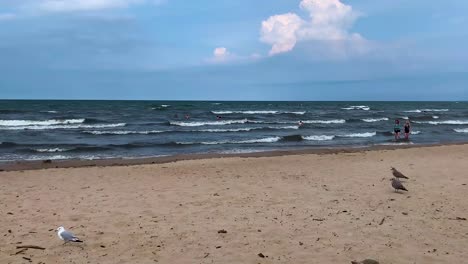 People-enjoying-having-fun-in-the-ocean-sea-water-at-cedar-point-beach-in-sandusky,-ohio,-united-states