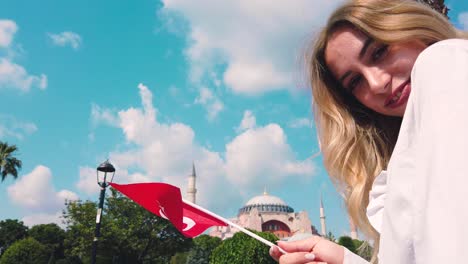 Schönes-Junges-Mädchen-Nimmt-Selfie-Und-Winkt-Türkische-Flagge-Vor-Einem-Alten-Gebäude-In-Lstanbul,-Türkei,-Reisekonzept