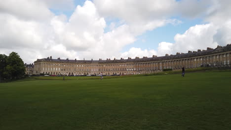 Static-Shot-of-Pedestrians-Walking-in-front-of-the-Royal-Crescent-in-Bath,-Somerset-on-a-Cloudy-Summer’s-Day