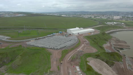 An-aerial-view-of-the-exterior-of-a-concrete-plant-at-Nigg-Bay,-Aberdeenshire,-showing-concrete-tetrapods-lined-up-in-storage-outside