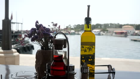 Olivenöl,-Balsamico-Pfeffer-Und-Salz-Stehen-Auf-Dem-Tisch-In-Einem-Restaurant-Mit-Blick-Auf-Den-Hafen-Von-Krk,-Kroatien
