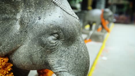 Close-up-of-elephant-statue-head-with-garland