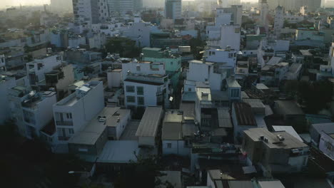 Am-Frühen-Morgen-Fliegt-Man-Kurz-Nach-Sonnenaufgang-über-Die-Dächer-Von-Häusern-Im-Bezirk-Binh-Thanh-In-Ho-Chi-Minh-Stadt,-An-Einem-Tag-Mit-Sehr-Hoher-Luftverschmutzung
