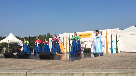 Women-in-traditional-costume,-hanbok,-perform-dance-at-Olympic-Park,-Oryun-dong,-Songpa-gu,-Seoul,-South-Korea