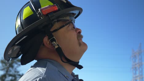 El-Bombero-Mira-Hacia-Arriba-En-El-Aire-A-Una-Escalera-Que-Controla-En-Un-Camión-De-Bomberos