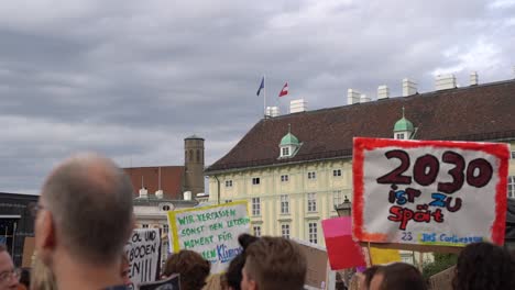 Blick-Auf-Die-Menschenmenge,-Die-Freitags-Schilder-Mit-österreichischer-Und-Europäischer-Flagge-Im-Hintergrund-Für-Künftige-Klimaschutzproteste-In-Zeitlupe-Hochhält