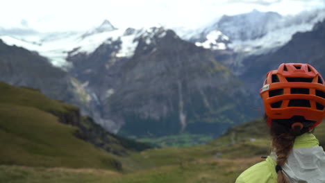 Mujer-Ciclista-De-Montaña-Contemplando-Los-Alpes-Suizos-Cubiertos-De-Nieve