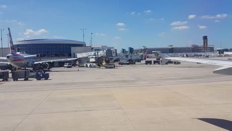 Riding-in-airplane-through-tarmacs-to-gate,-plane-taking-off-in-background