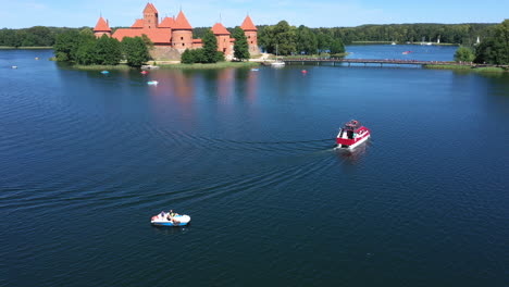 AERIAL:-Two-Boats-Sailing-in-the-Blue-Color-Lake-Near-Trakai-Castle-on-a-Bright-Sunny-Day