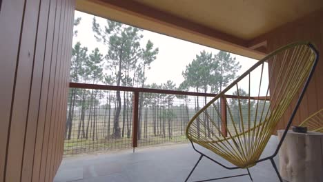 Pov-ähnliche-Aufnahme-Eines-Balkons-Mit-Stuhl-Und-Nebligem-Wald
