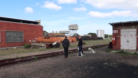 Two-teenagers-in-abandoned-train-yard-playing-with-rail-track-controls
