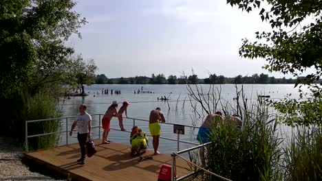Panning-view-of-people-enjoying-hot-summer-weather-at-the-lake