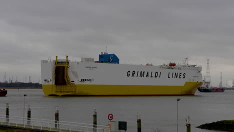 A-large-white-and-yellow-shipping-vessel-from-Grimaldi-Lines-leaving-the-docks-of-the-Antwerp-Harbor---Wide-shot