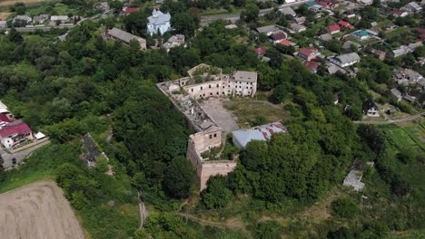Aerial-View-of-Old-Abandoned-Building-Surrounded-by-Neighborhood-and-Trees