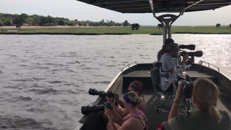 Fotografenboot-Dreht-Sich-Im-Fluss-Um,-In-Der-Nähe-Afrikanische-Elefanten