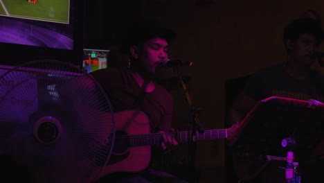 Thailändischer-Mann-Mit-Hut,-Der-Gitarre-Auf-Der-Khaosan-Road-In-Bangkok,-Thailand,-Spielt