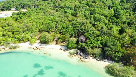 Tranquil-secret-exotic-beach-with-white-sand-and-turquoise-lagoon-with-coral-reefs-on-tropical-island-with-trees-forest-in-koh-phangan,-Thailand