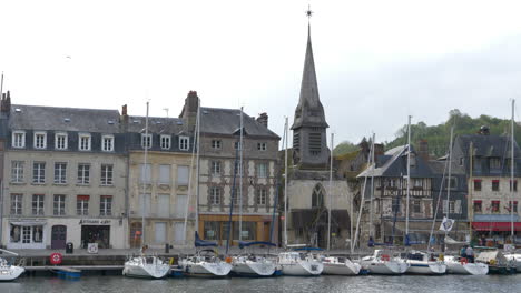 Waterside-with-ancient-buildings-and-church-in-Honfleur,-famous-french-town-in-Normandy