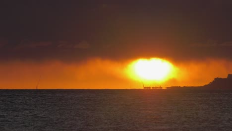 Sun-on-ocean-horizon-with-dark-clouds