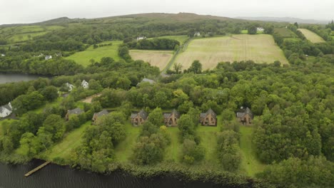 Fly-in-establishing-shot-of-holiday-rentals-next-to-a-beautiful-lake-in-Ireland
