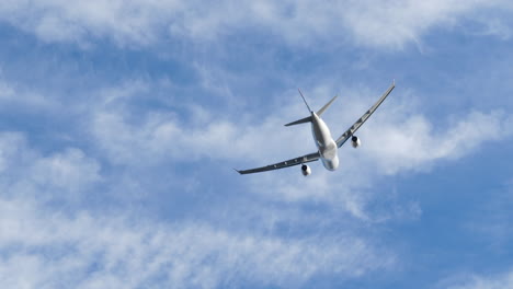 Tracking-close-up-slow-motion-shot-from-below-of-an-Edelweiss-A330-airplane-after-take-off-with-fluffy-clouds-on-the-background,-Zurich-Airport-,-Switzerland