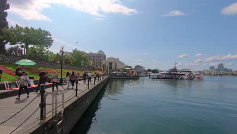 View-Of-People-Walking-On-Path-Next-To-Marina-Harbor-In-Victoria,-Canada