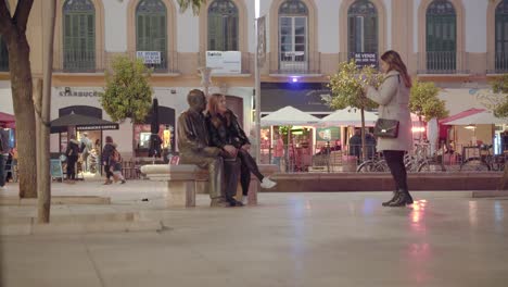 Tourists-taking-photos-with-Picasso`s-statue-in-Malaga---PANNING-RIGHT