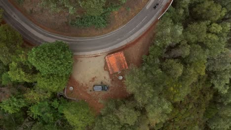 Aerial-descending-orbit-over-small-house-with-bike-passing-by-on-road