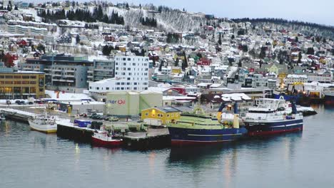 Cargo-ships-parked-at-the-port-of-a-northern-city-Tromso-Norway-in-winter