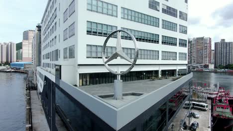 Großes-Mercedes-Benz-Zeichen-Dreht-Sich-Auf-Hongkong-Mercedes-Benz-Hauptausstellungsraum-In-Chai-Wan,-Luftbild